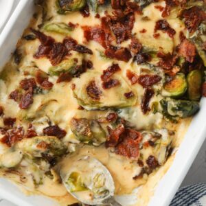 Brussel sprouts in a casserole dish topped with bacon.