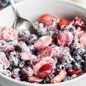 Creamy fruit salad with yogurt served in a bowl.