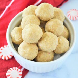 A bowl filled with Christmas Protein Balls made with almond butter and candy cane bites.