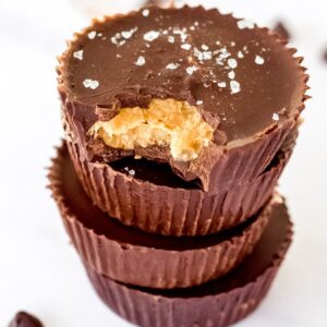 Healthy peanut butter cups stacked on top of each other with a bite taken out.