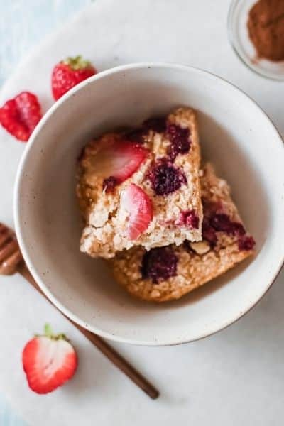 Berry baked oatmeal being served in a white bowl.