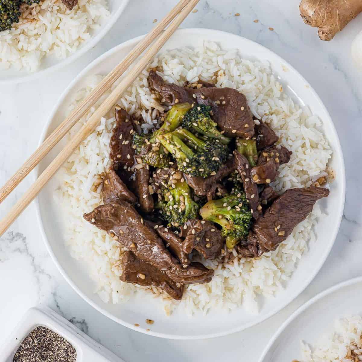 Beef and broccoli served in a bowl over white rice.