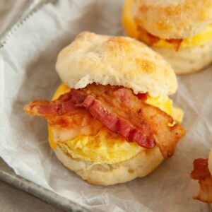 Biscuit cut in half with bacon and egg.