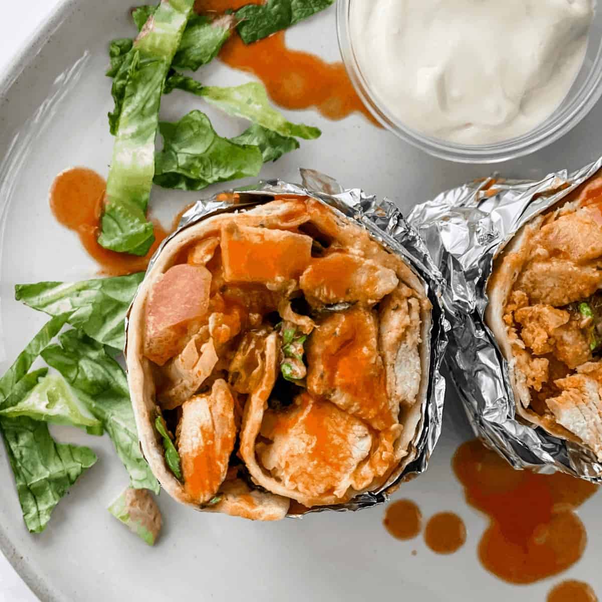 This quick and easy Buffalo Chicken Wrap includes spicy Buffalo chicken tenders, crunchy veggies, and creamy blue cheese yogurt dressing! It comes together in less than 30 minutes, making it perfect for a healthy weeknight meal