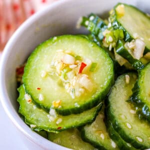 Asian cucumber salad in a white bowl.