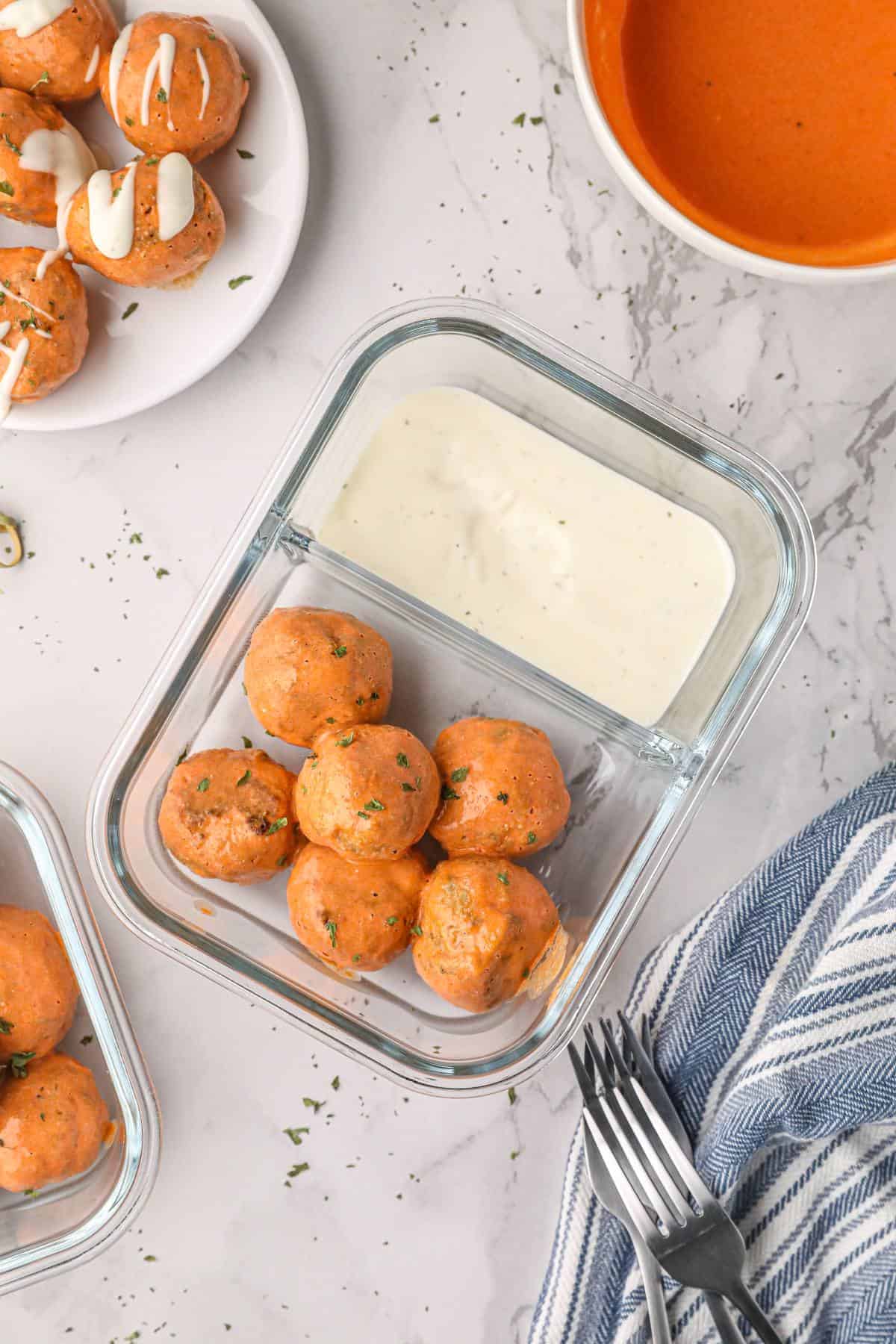 Buffalo turkey meatballs and ranch in a meal prep container. 