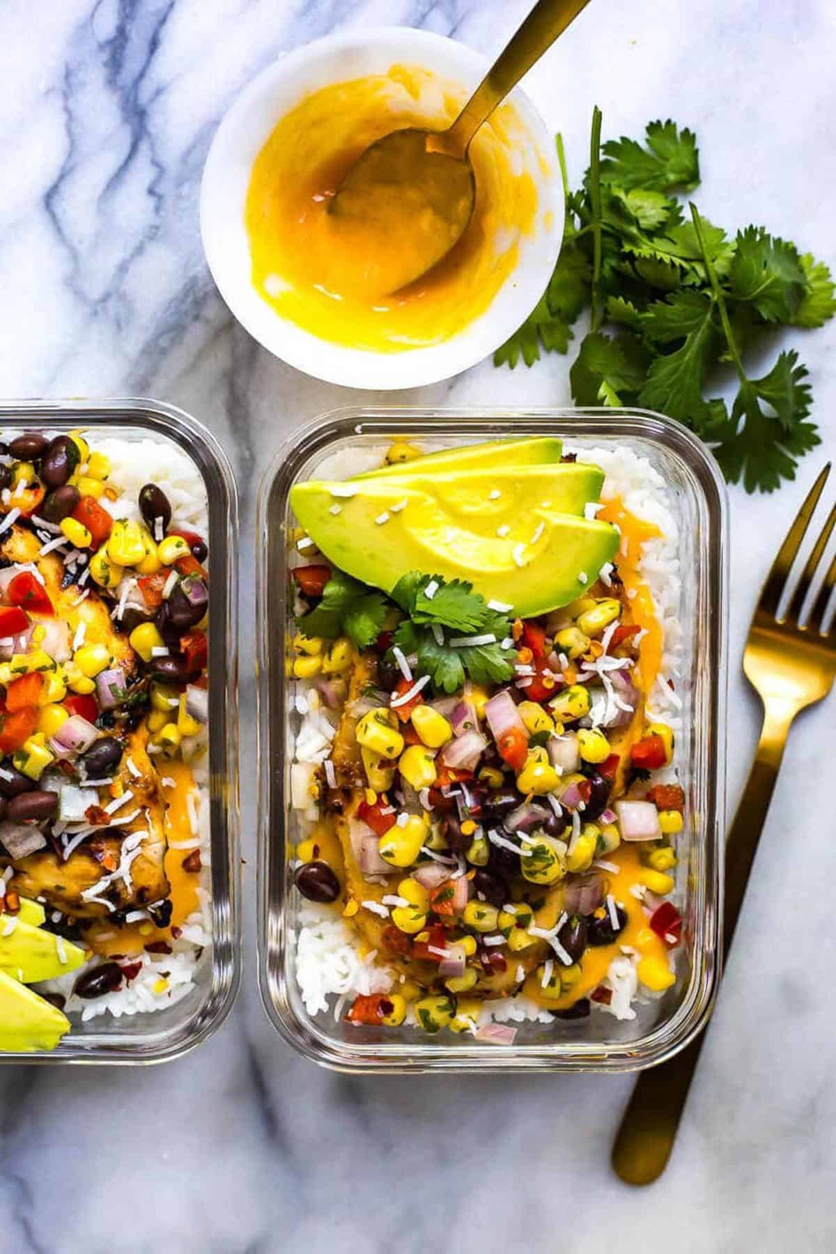 Coconut mango chicken, corn, and rice in meal prep bowls. 