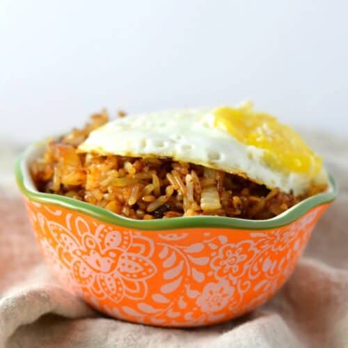 Kimchi fried rice in a bowl with an egg on top.