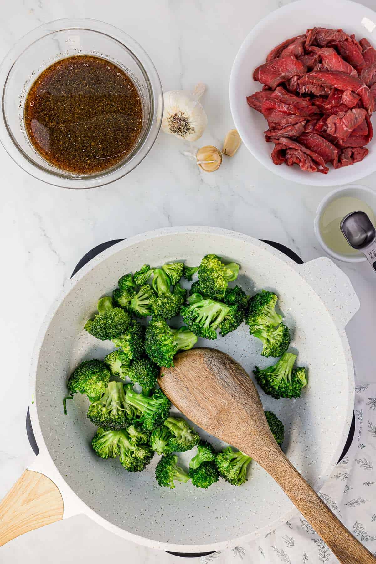Broccoli being stir-fried in a pan. 
