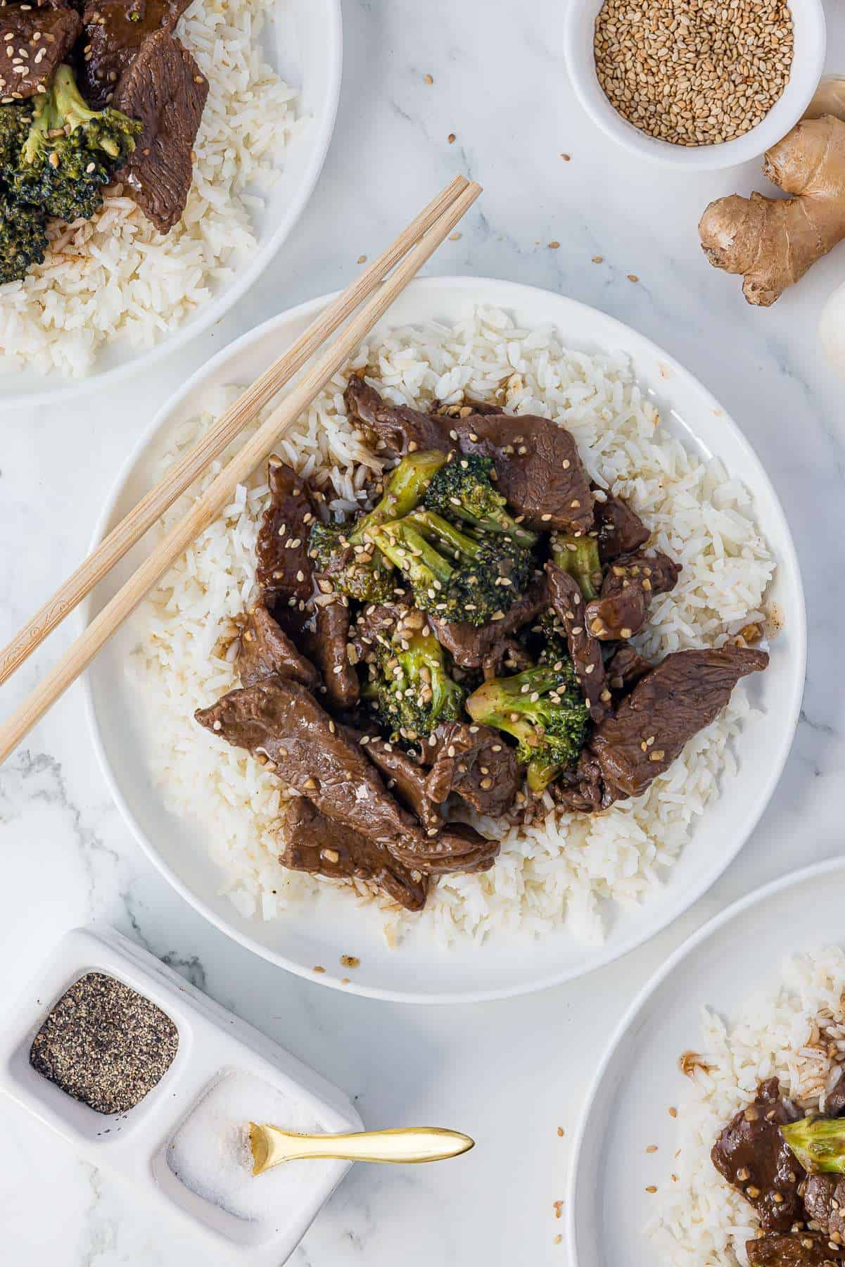 Beef and broccoli over white rice in a white bowl. 