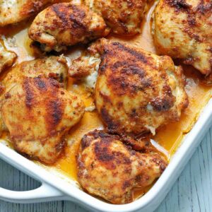 Chicken thighs in a baking pan.