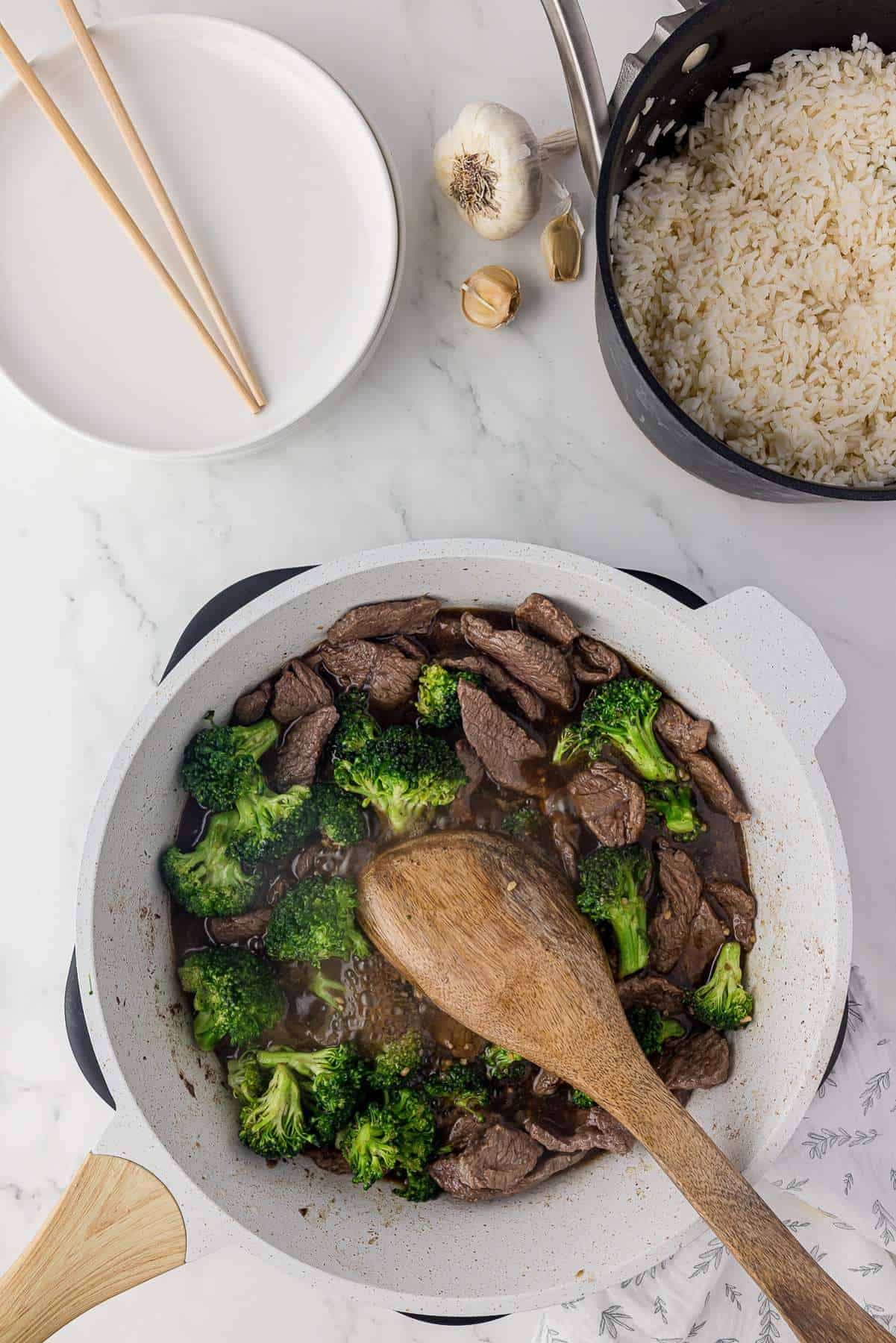 Beef and broccoli being stir-fried in a sauce. 