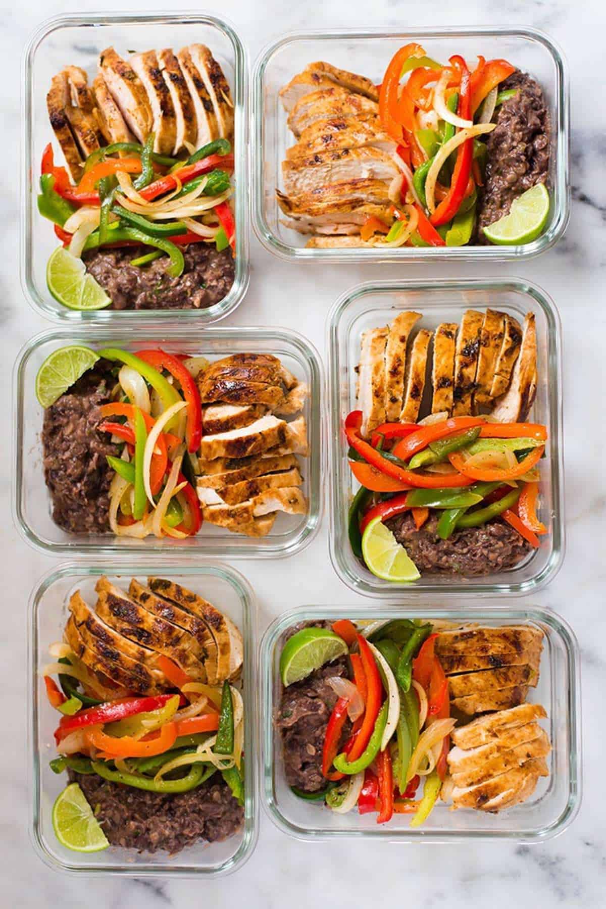 Chicken fajitas and beans in meal prep containers. 