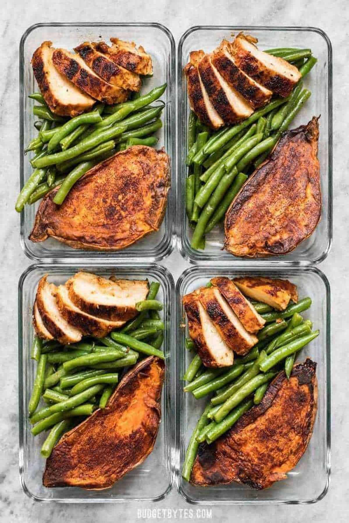 Chicken, green beans, and sweet potatoes, in meal prep containers. 