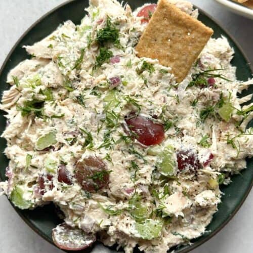 Chicken salad served in a bowl with crackers.