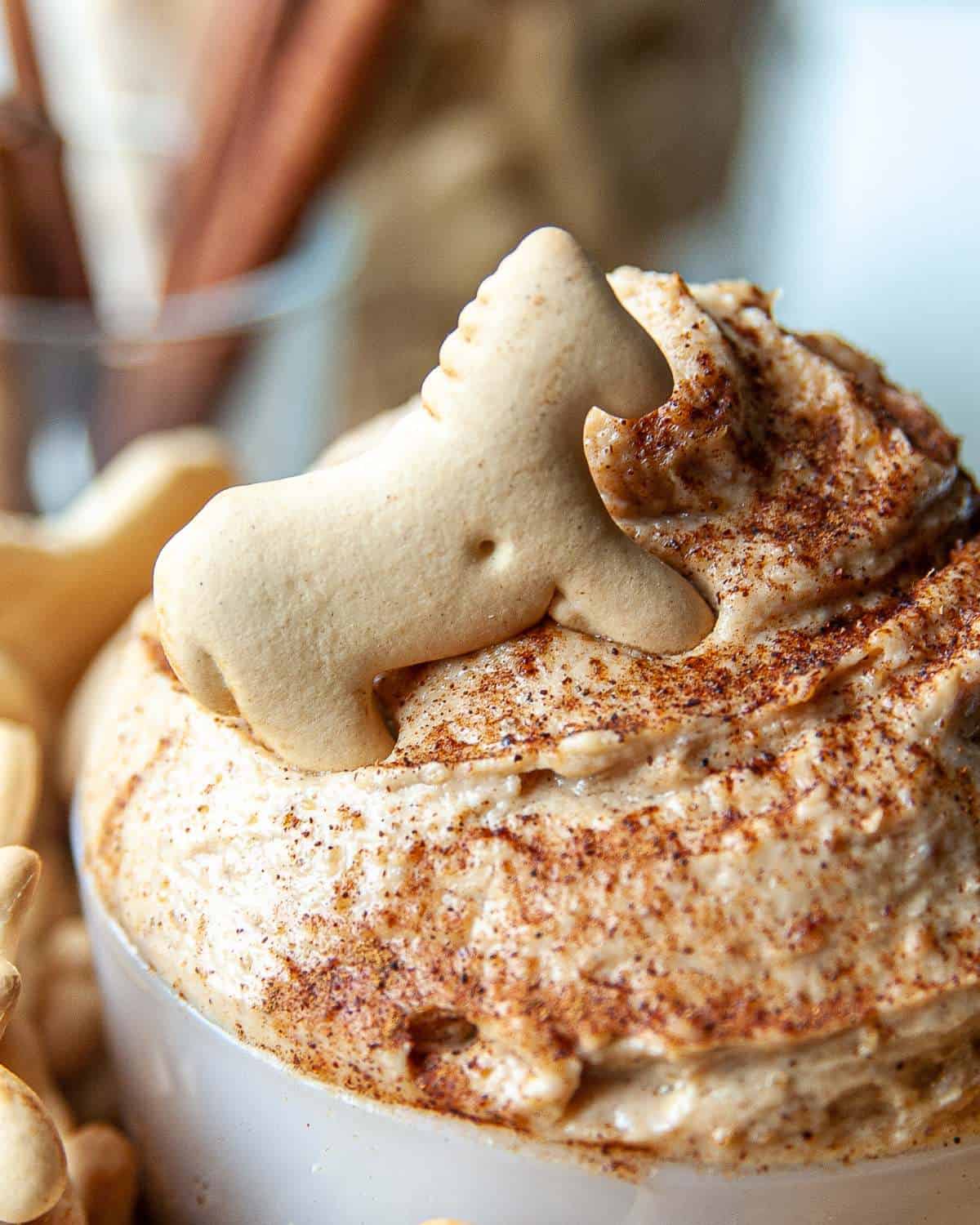 Peanut butter yogurt dip being served in a bowl with animal crackers. 