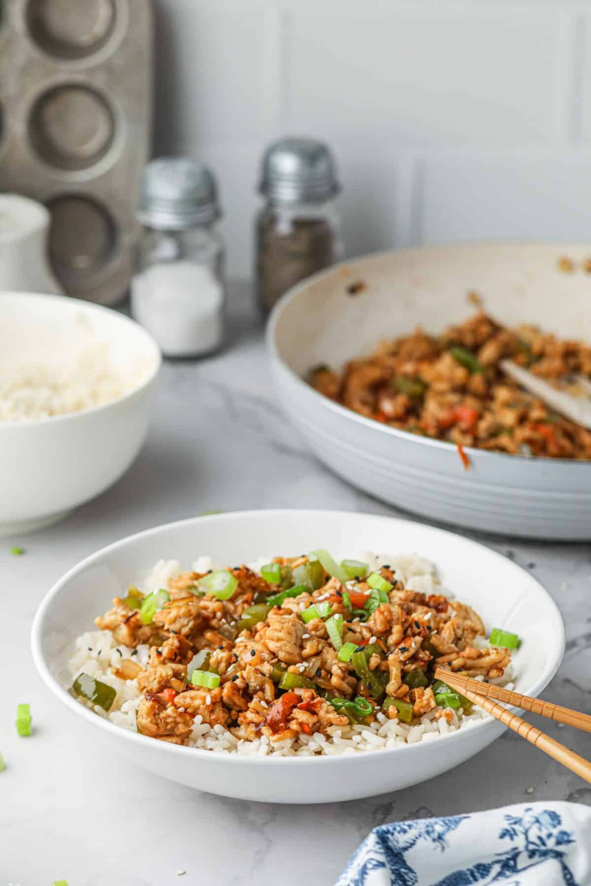 Ground turkey teriyaki being served over rice in a bowl. 
