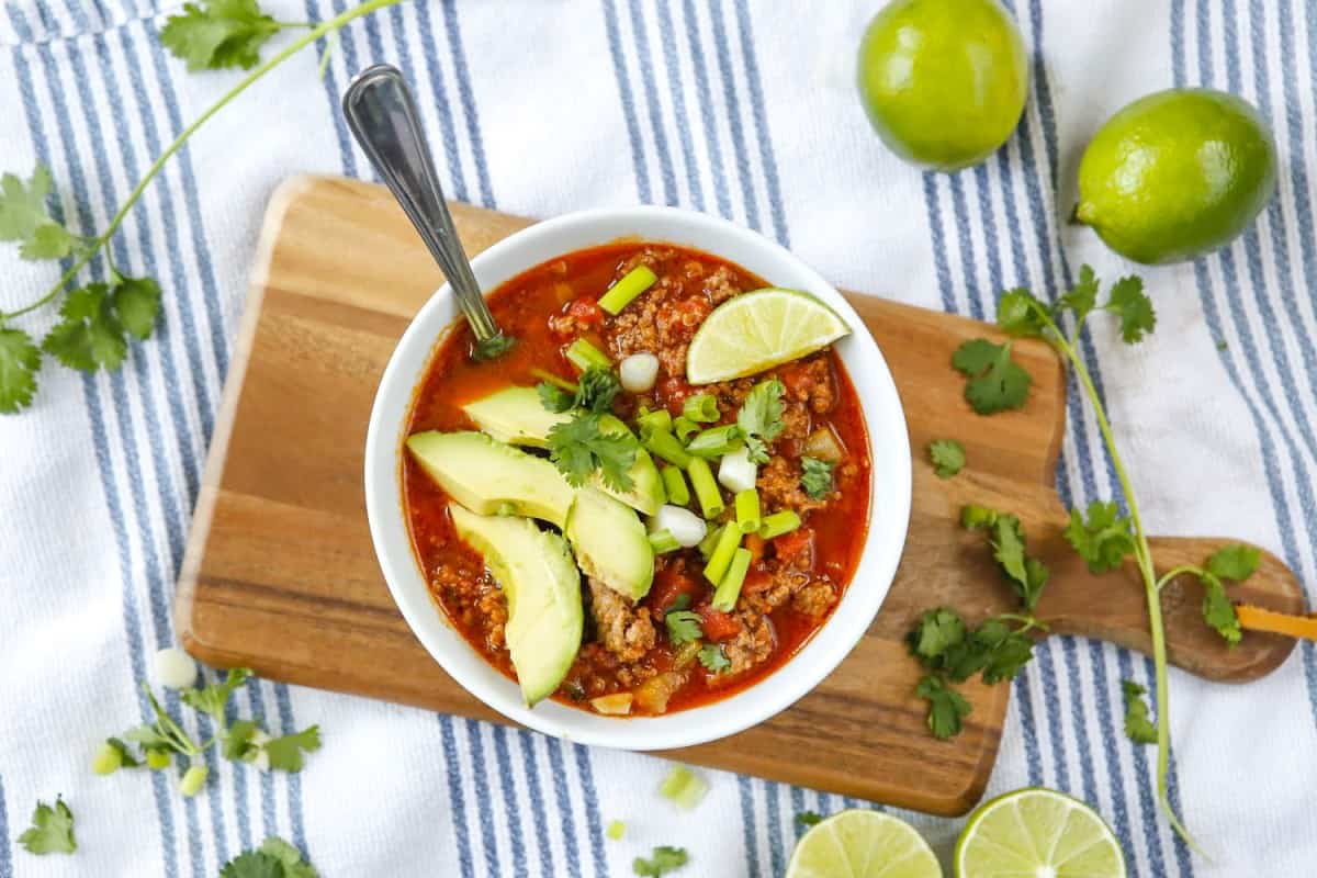 No bean chili served in a bowl with avocado and lime on top. 