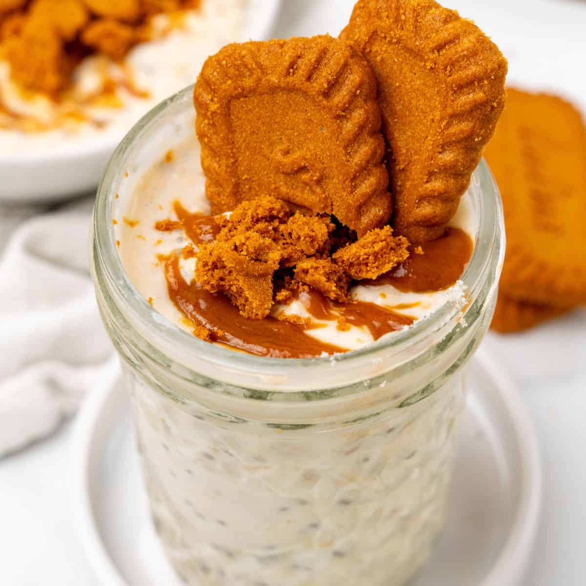 Overnight oats in a mason jar with crushed lotus cookies and lotus biscoff spread.