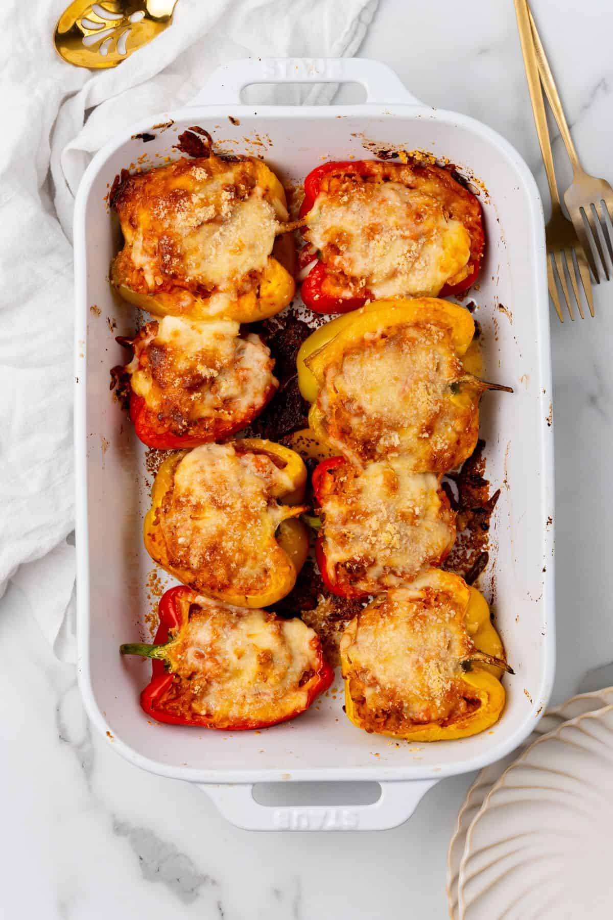 Stuffed peppers featuring ground chicken in a white baking dish.