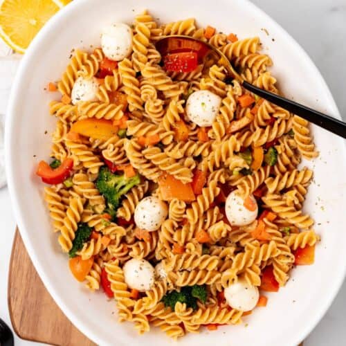 A white bowl filled with protein-packed pasta and a colorful array of vegetables.