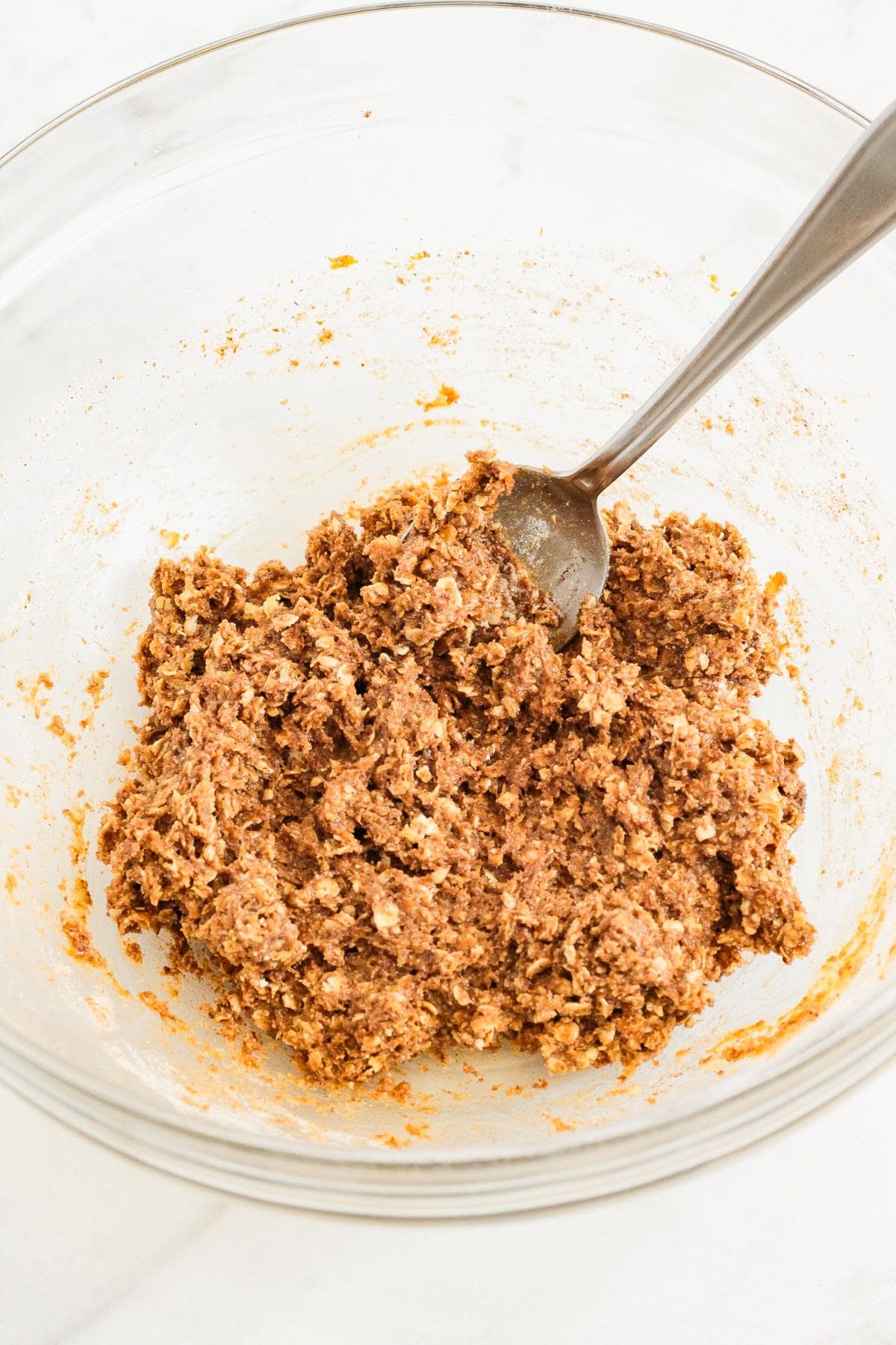 A bowl of pumpkin protein bar ingredients being mixed together.