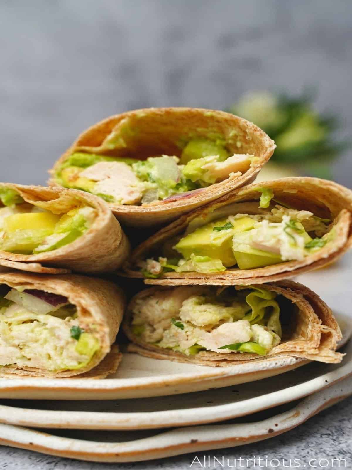A stack of chicken avocado wraps on a plate.