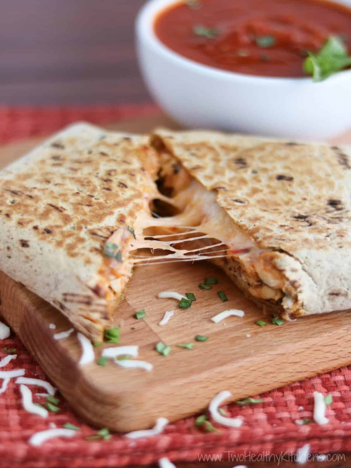 A healthy chicken parmesan wrap with sauce on a cutting board.