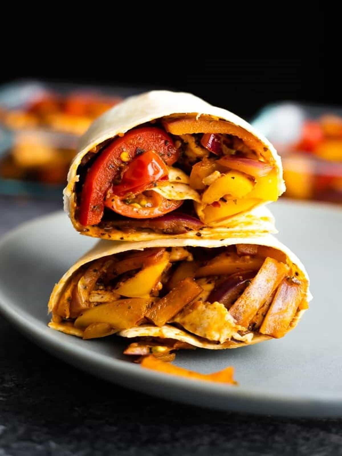 A Cajun chicken wrap is stacked on top of a plate.