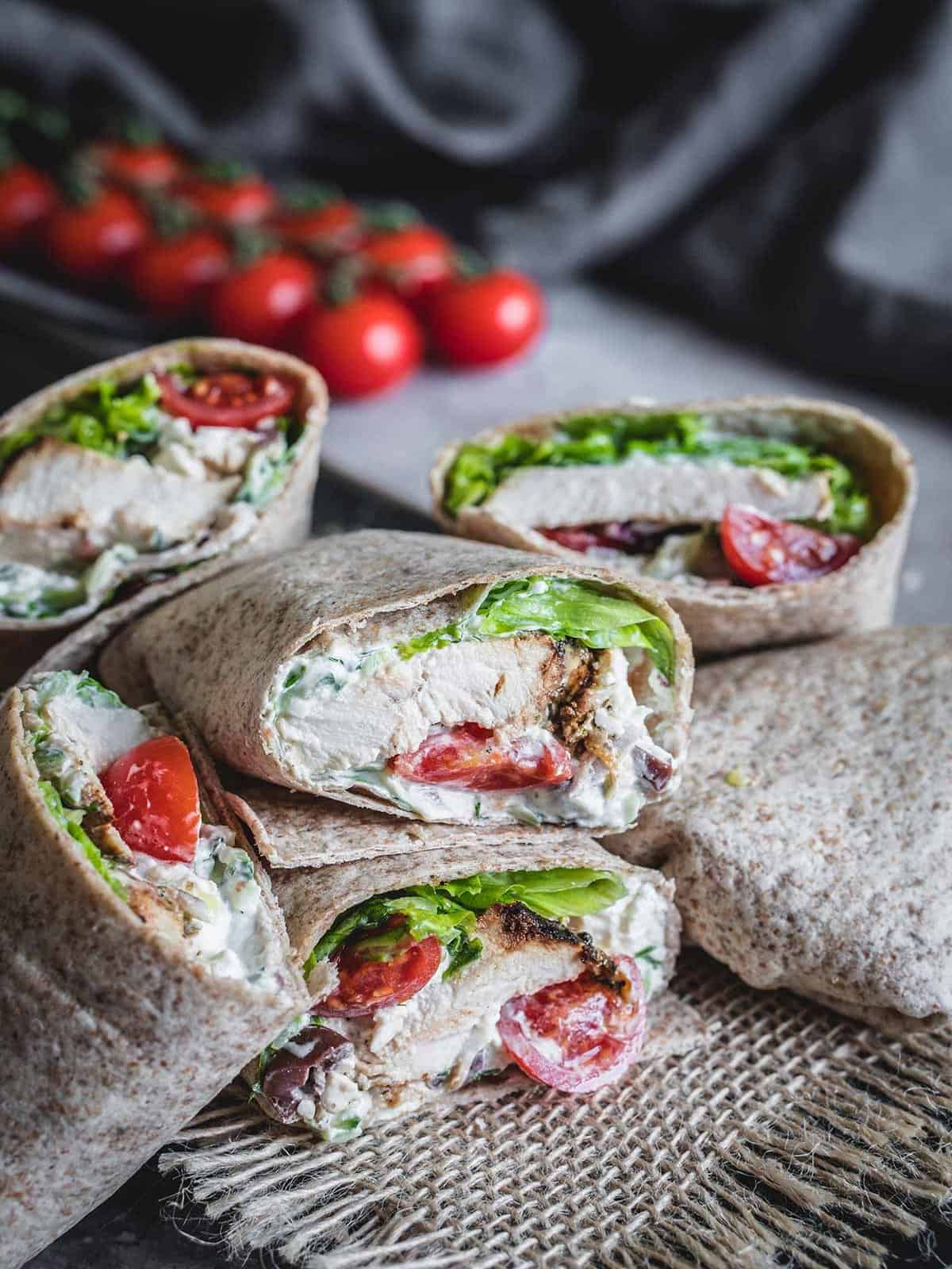 Greek chicken wraps with tzatziki sauce on a placemat. 