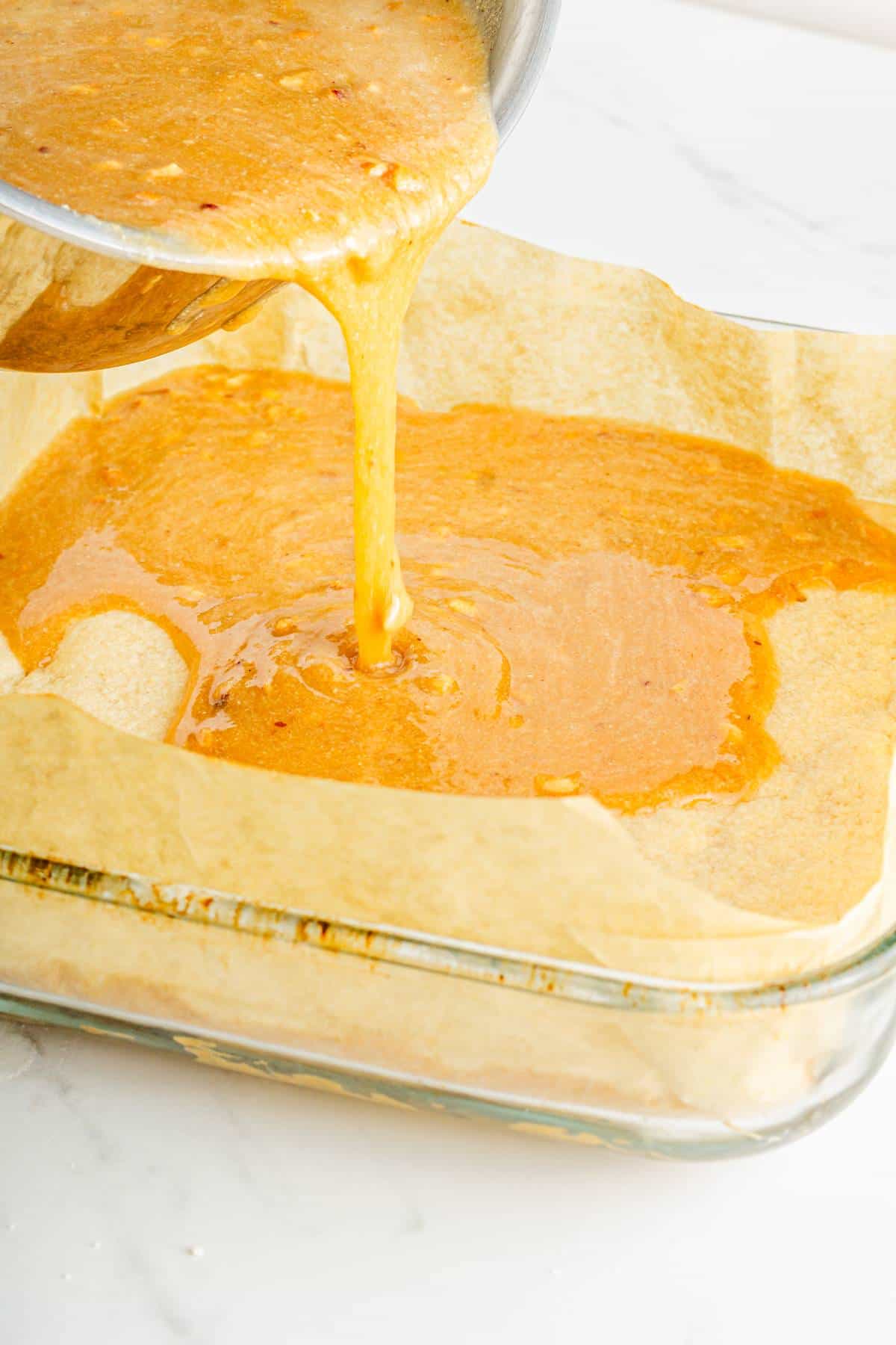 A baking dish with a protein-packed caramel sauce being poured into it.