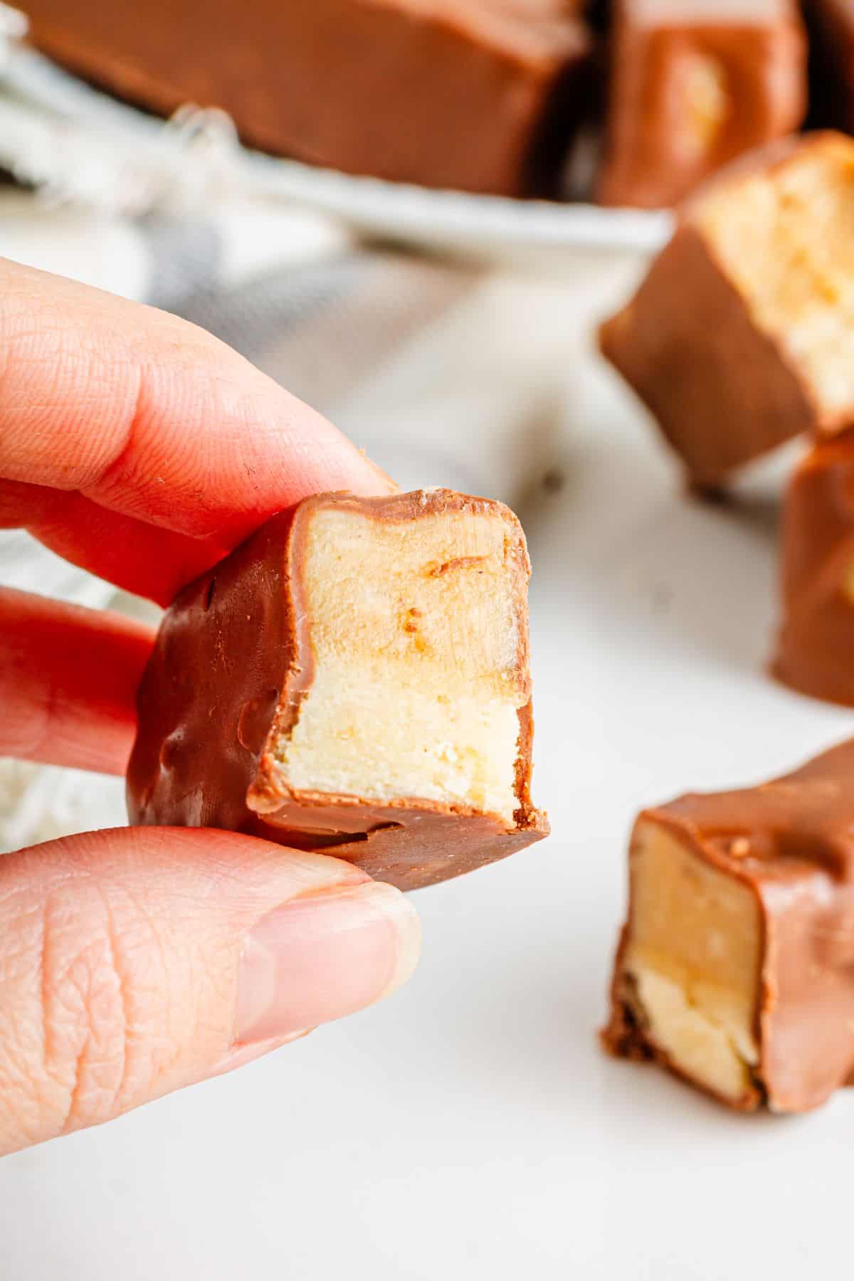 A person holding in a protein-packed Twix Bar.