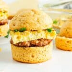 A plate of sausage breakfast sandwiches on a white table.