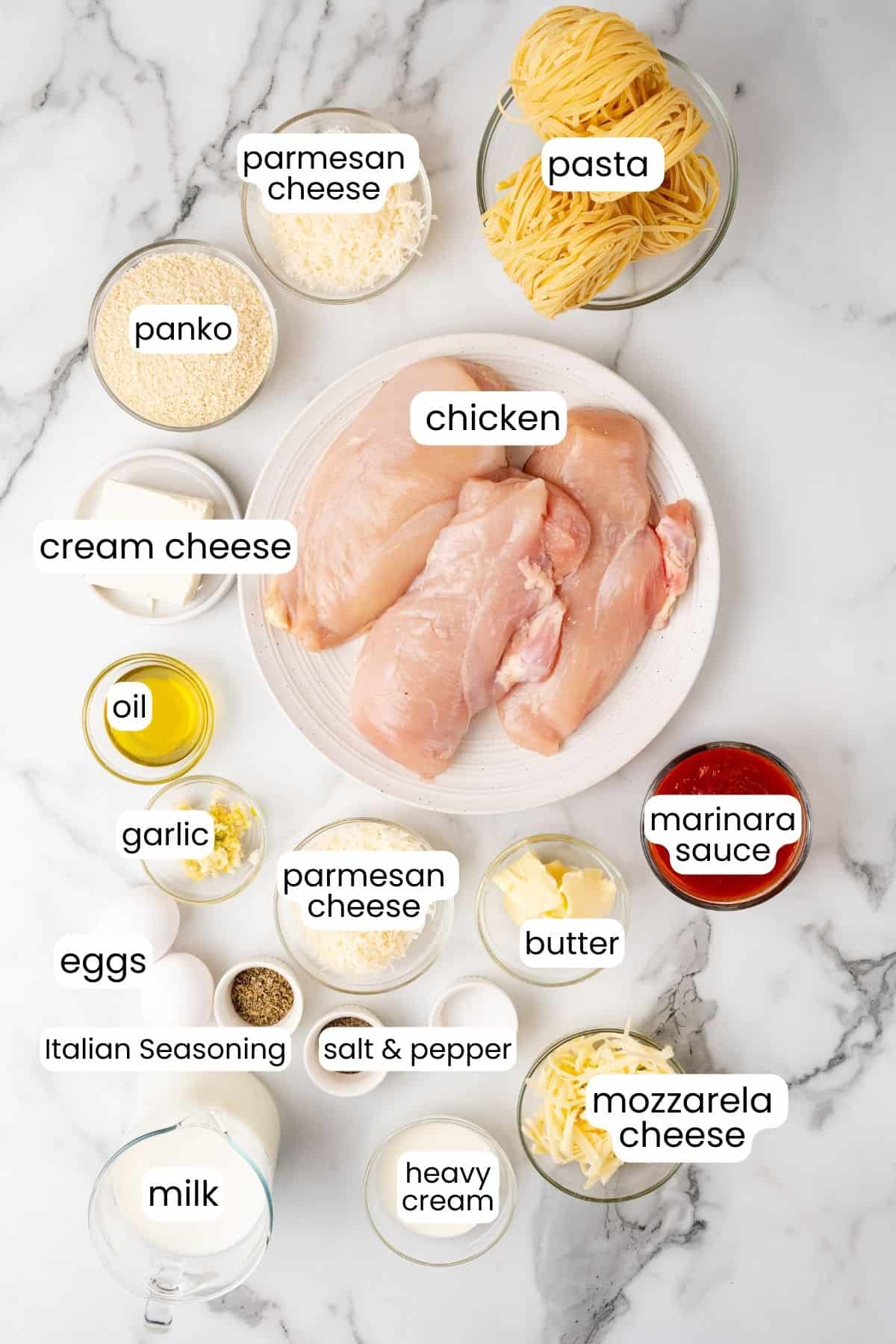 Ingredients for Chicken Parmesan Alfredo recipe arranged neatly on a marble surface.