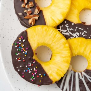 Chocolate covered pineapple on a white platter.