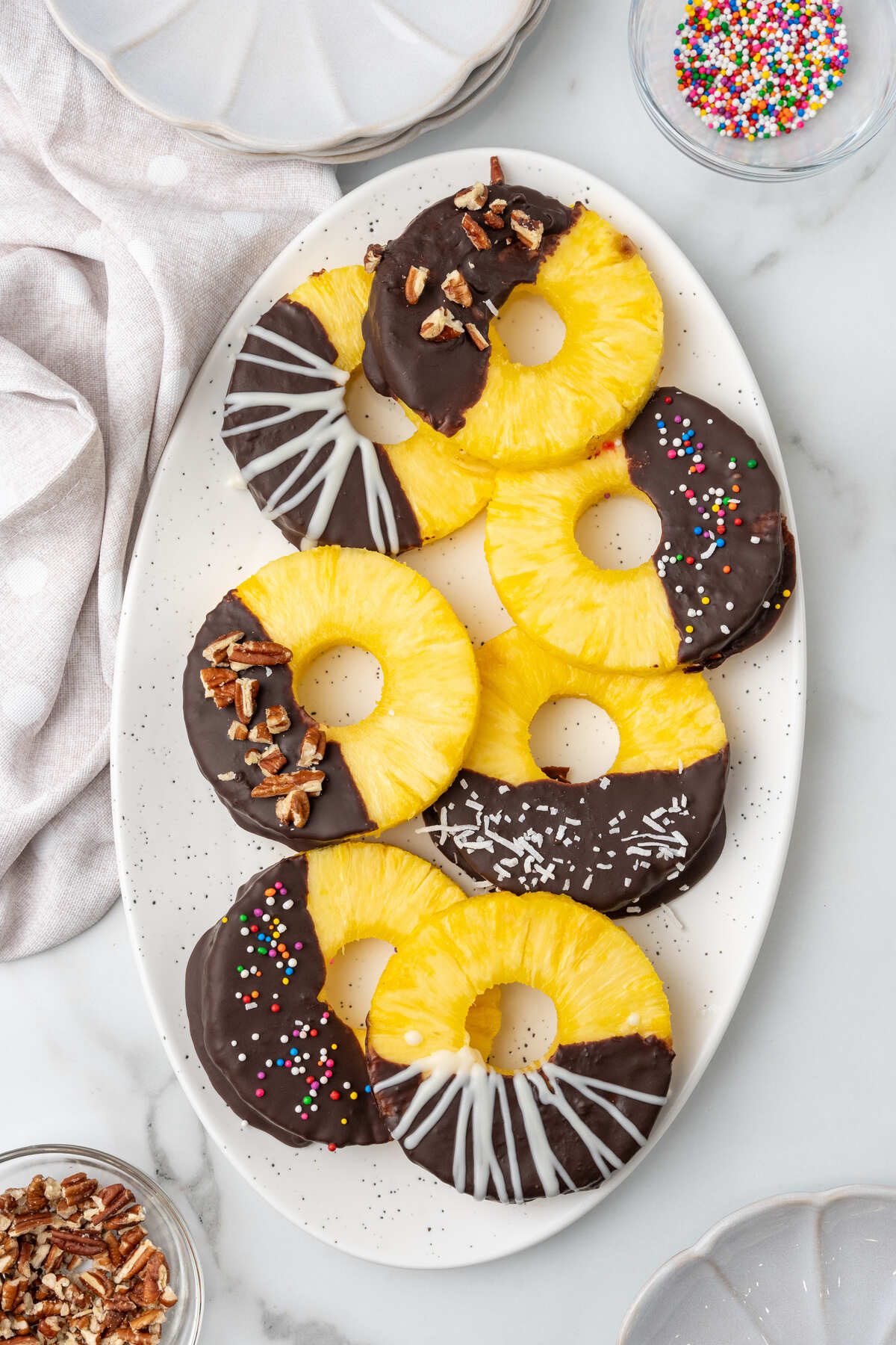 Chocolate dipped pineapple on a white platter. 