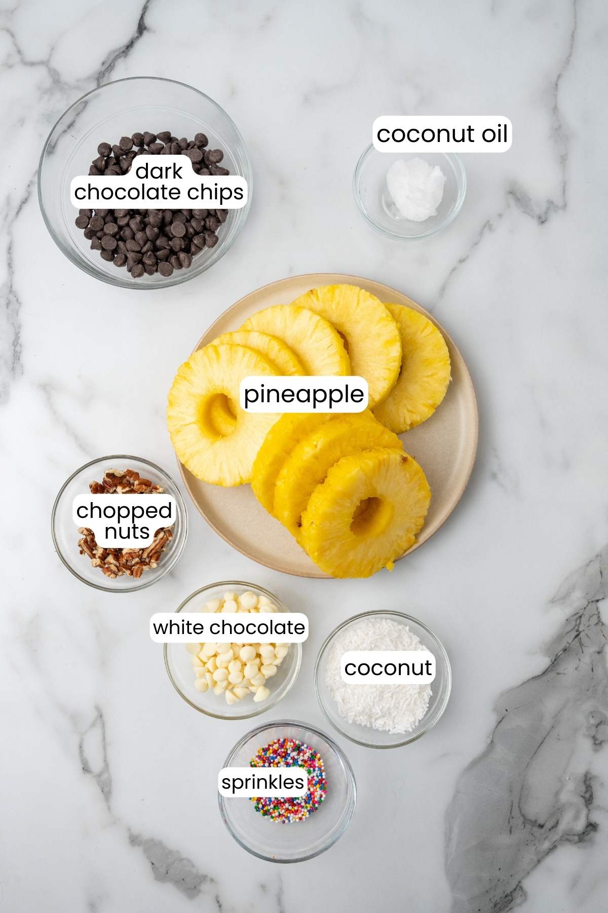Ingredients for chocolate covered pineapple on a marble countertop.