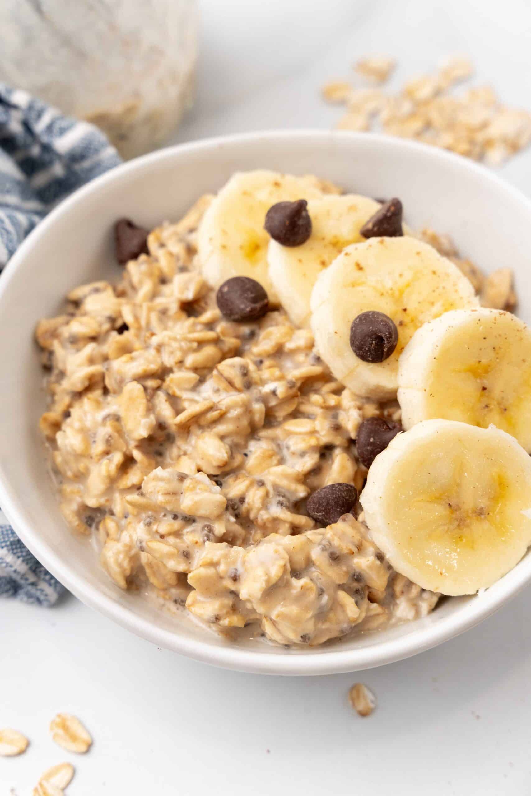 A delightful bowl of overnight oats made with Pb2, topped with sweet banana slices and rich chocolate chips.