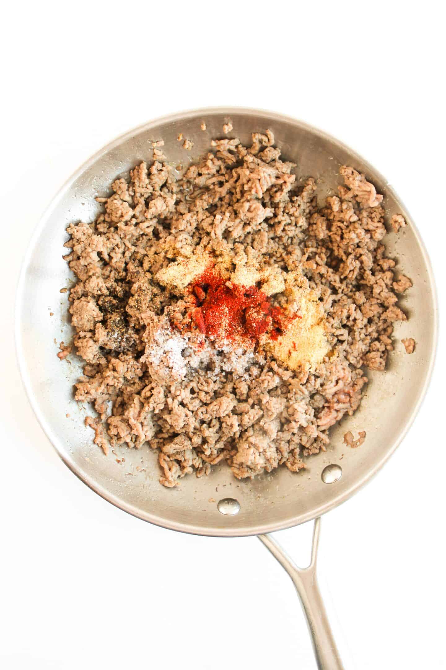 Ground beef sizzles in a skillet, infused with spices like paprika, salt, and pepper, reminiscent of that savory Crunchwrap taste.