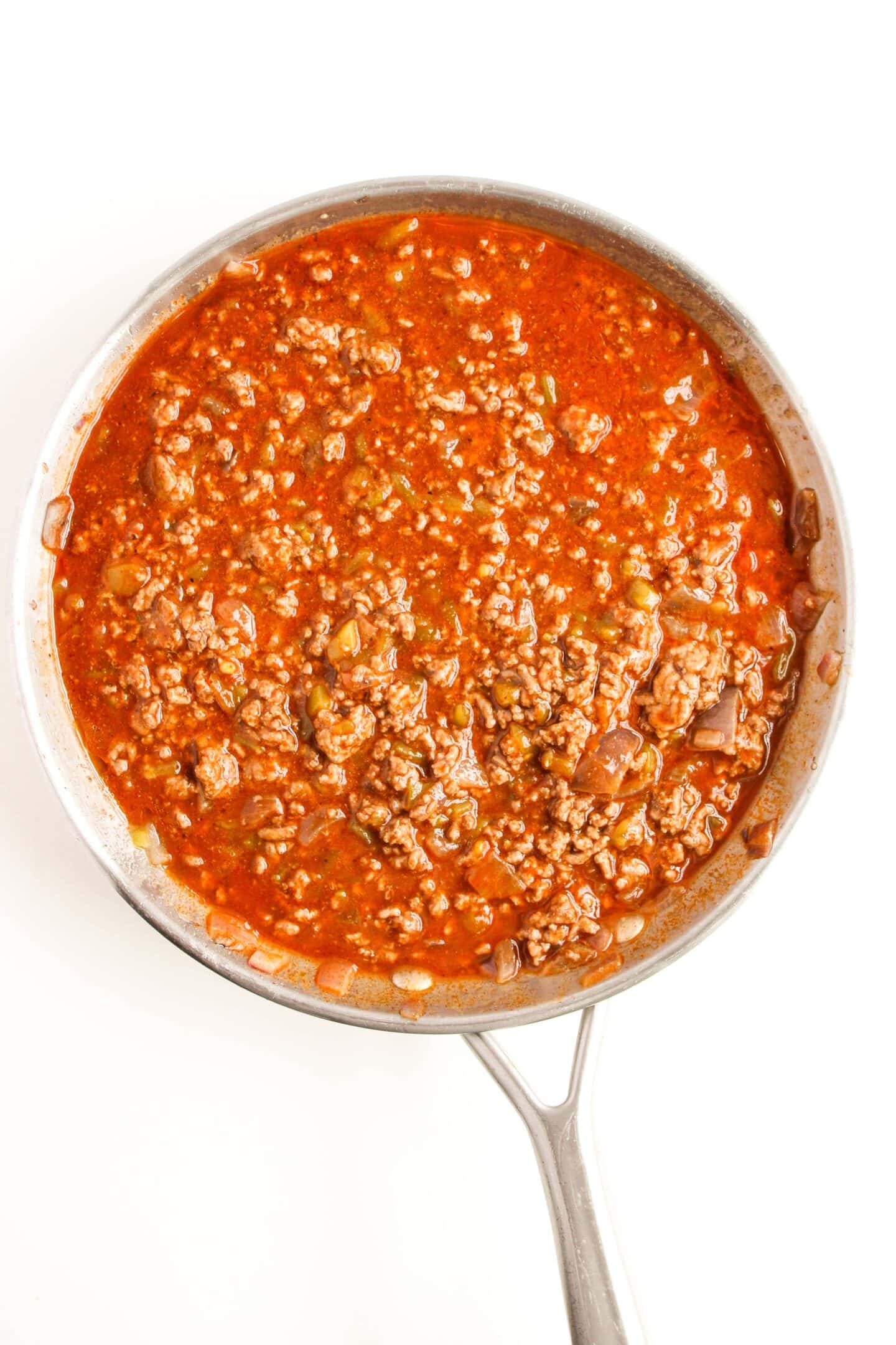 A skillet filled with hearty ground beef and rich tomato sauce creates a savory base perfect for enchilada night.