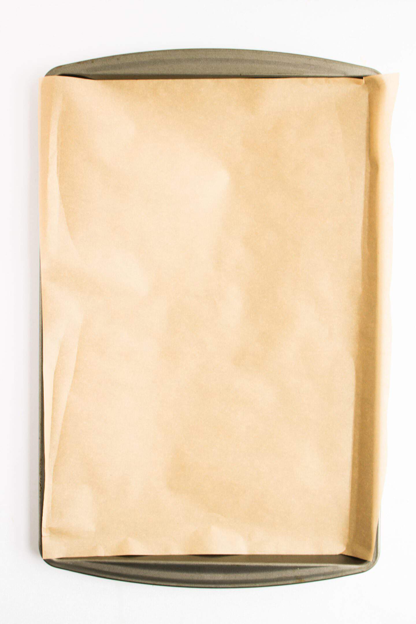 Baking sheet lined with a sheet of parchment paper, ready for roasting sweet potato or making deliciously messy Sloppy Joes.