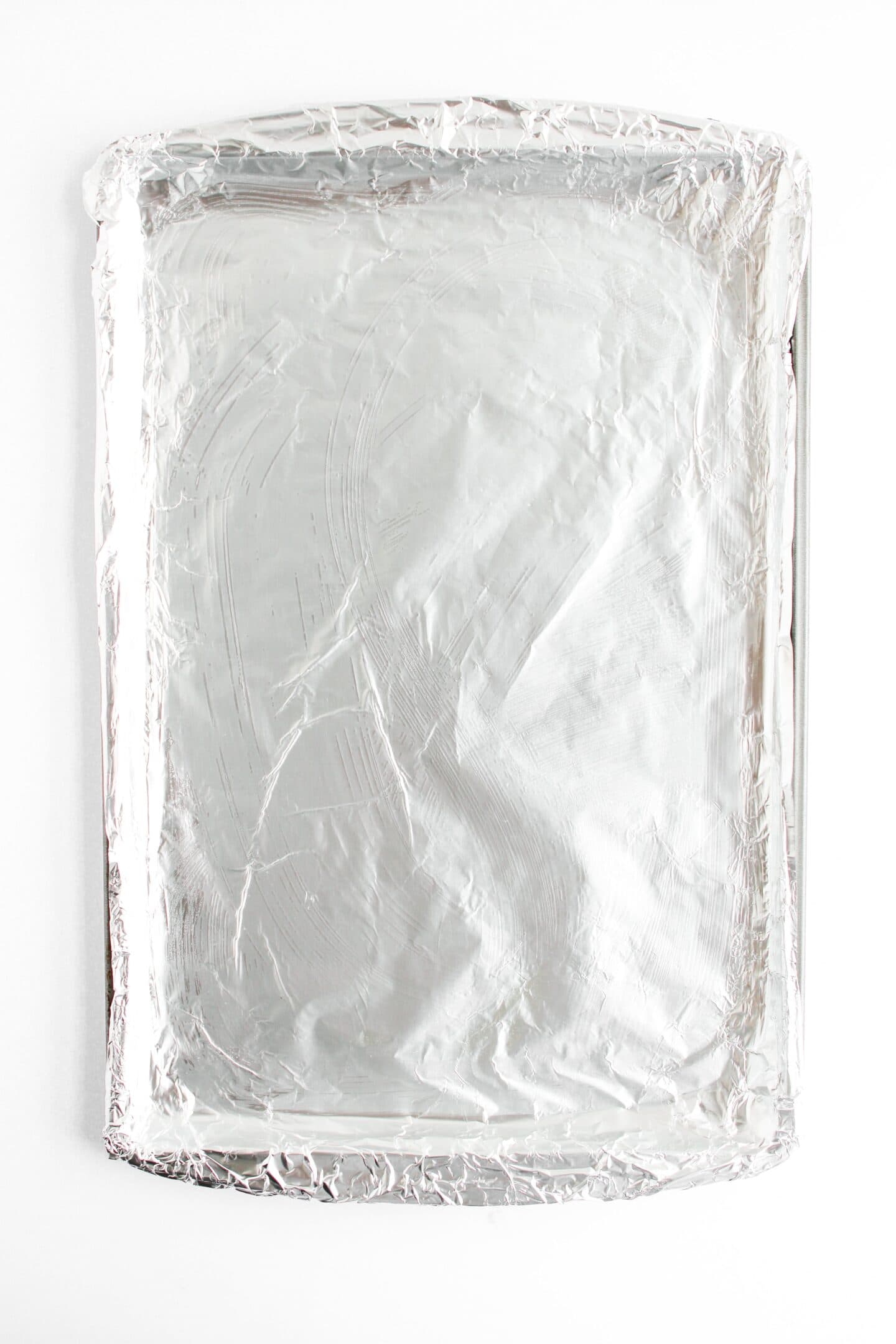 A baking sheet covered with crinkled aluminum foil, ready for the oven-baked salmon to be perfectly roasted, its surface soon to be a delectable blanket of panko-crusted goodness.