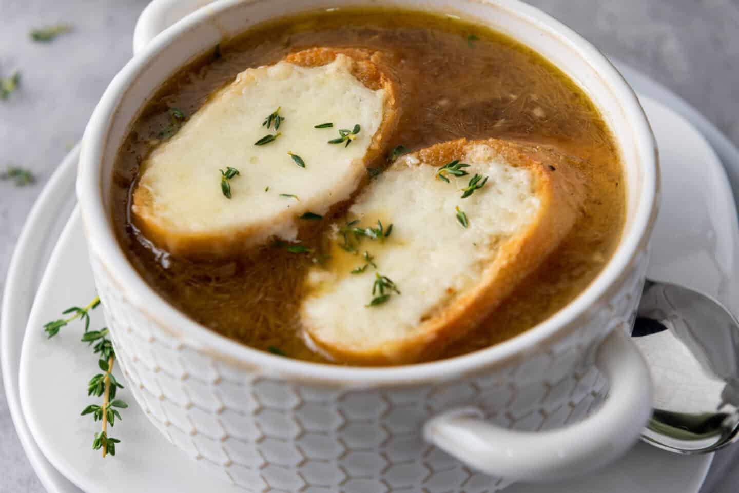 A bowl of soup with croutons and cheese.