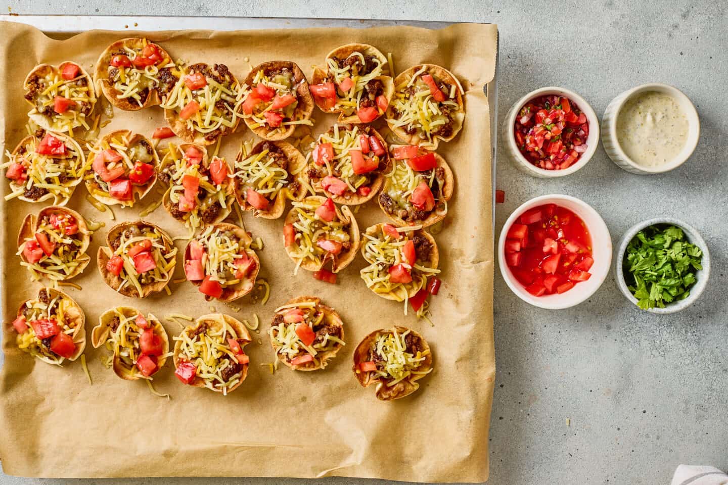 A tray of tasty bites served with salsa and ranch sauce.
