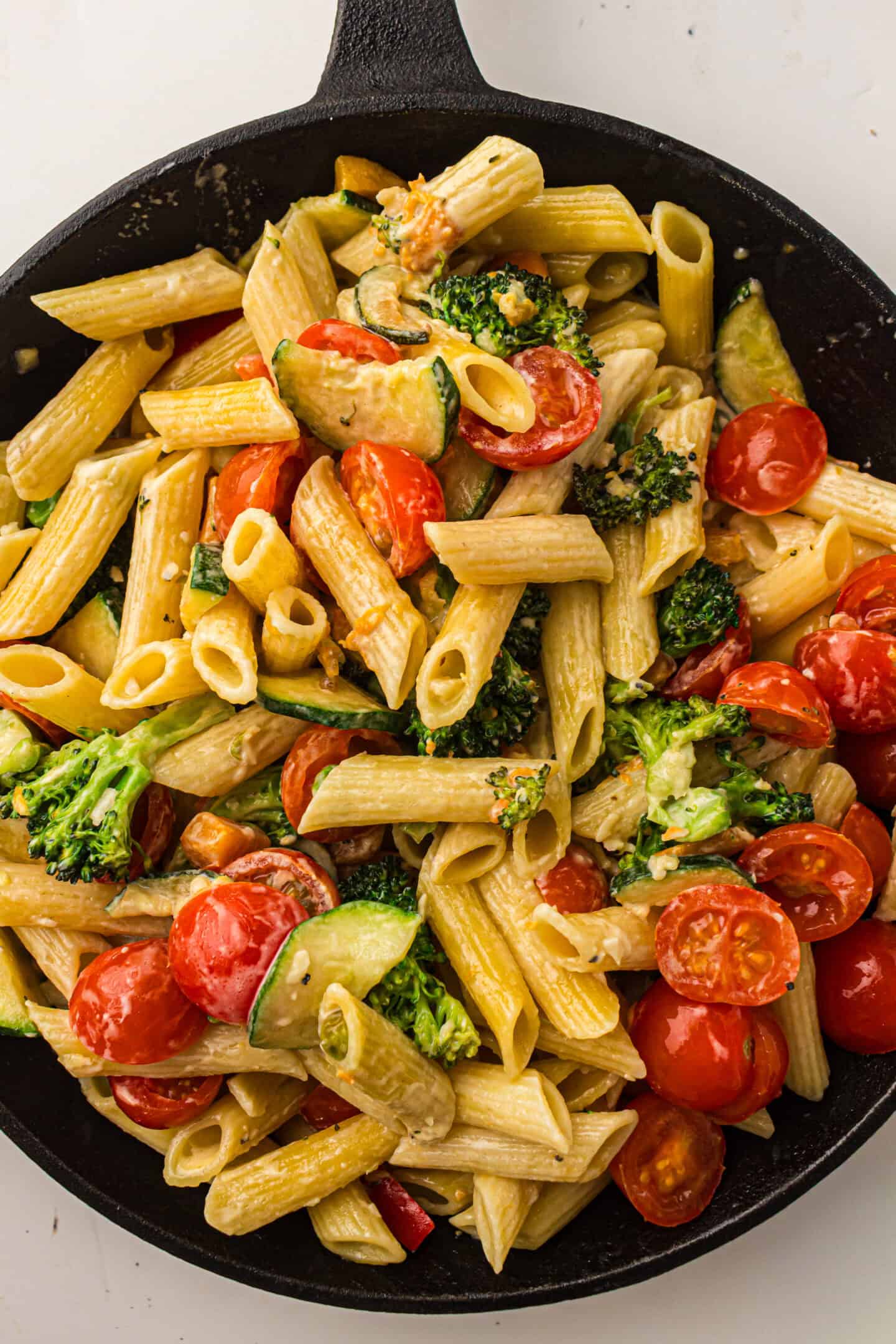 A skillet filled with Penne Pasta Primavera, cherry tomatoes, broccoli, and zucchini in a creamy sauce—an irresistible vegetable pasta recipe for any occasion.