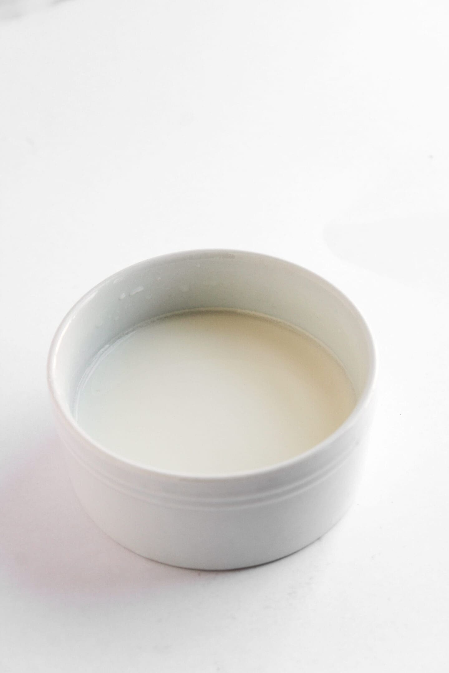 A white ceramic bowl filled with milk, placed on a plain white surface, reminiscent of the clean presentation often seen with Teriyaki Chicken Bowls.