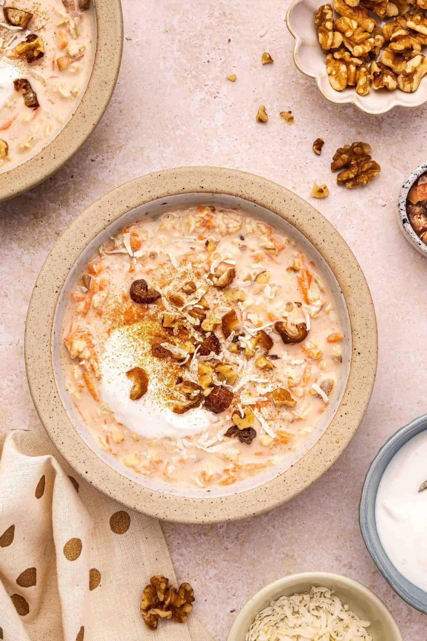 A bowl of oatmeal topped with shredded coconut, chopped walnuts, and spices, surrounded by small dishes of walnuts, coconut, and a creamy topping—perfect for a healthy breakfast without chia seeds.