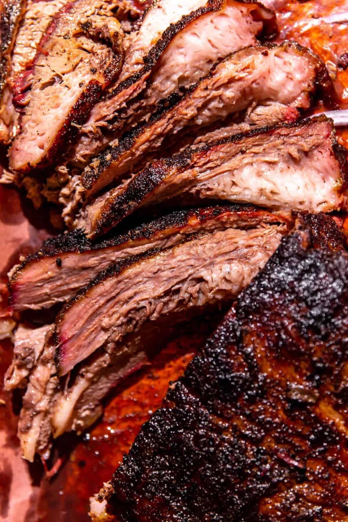 Close-up of sliced smoked beef brisket with a dark, seasoned crust and visible layers of juicy, tender meat—perfect for a memorable Father's Day dinner.