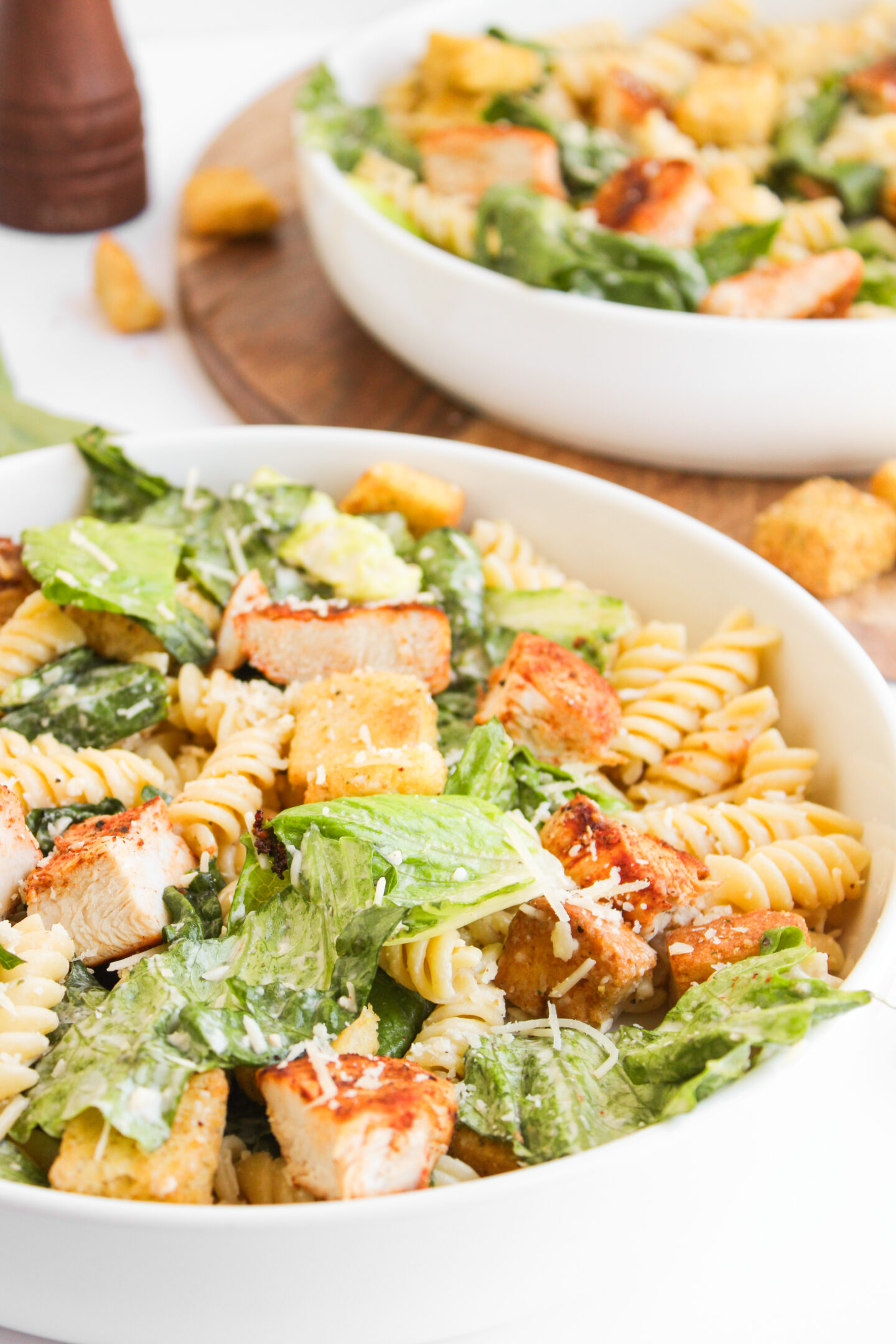 A bowl of pasta salad with grilled chicken, romaine lettuce, croutons, shredded cheese, and Caesar dressing—perfect for quick Sports Dinners.
