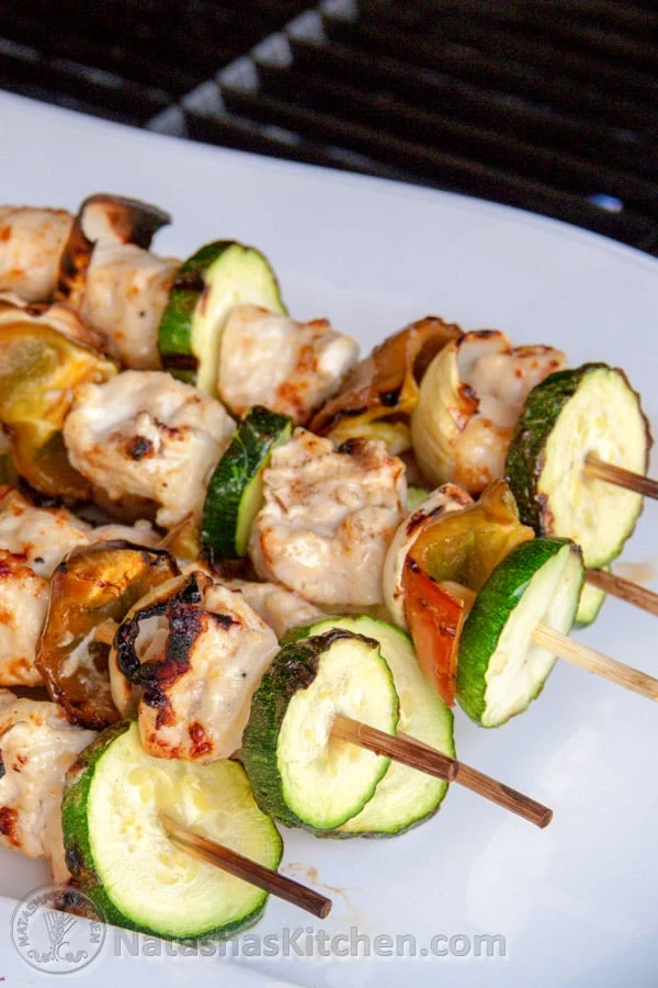 Grilled chicken and vegetable skewers with zucchini and bell peppers on wooden sticks, served on a white plate—perfect for Healthy Grilled Dinners.